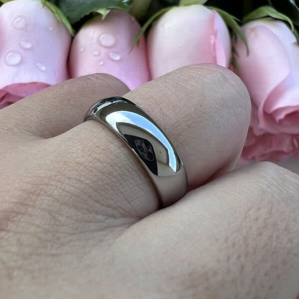 A ring finger wears The Bryant and showcases its dome design and polished finish.