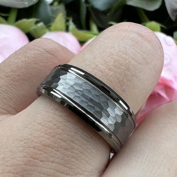A ring finger wears The Andrew to show its simple polished beveled edges and gunmetal hammered finish.