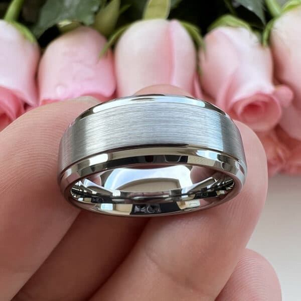 A plain silver-plated contemporary men's wedding ring featuring a wrap-around brushed finish and polished edges and sleeve.