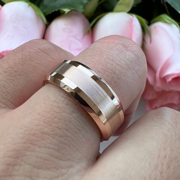 A contemporary wedding ring with classic vibes featuring gold plating, brushed center and polished beveled edges on a ring finger.