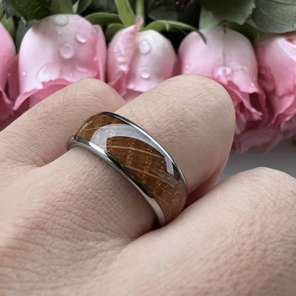 Nature-inspired 8mm wooden wedding band featuring a domed design, a whiskey barrel oak wood inlay, and a polished edge finish on a ring finger.