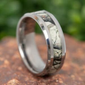 A simple men's wedding ring featuring beveled edges, a camo tree inlay, and a polished finish.