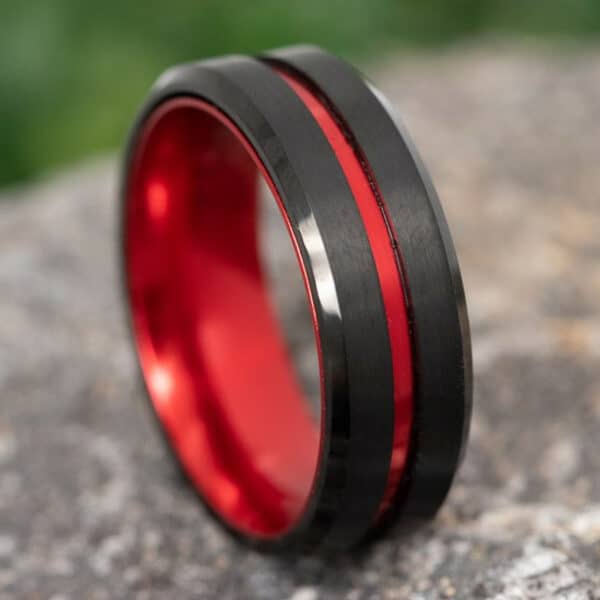 A classic black Tungsten ring with red-plated anodized aluminum stripes and matching red sleeves.