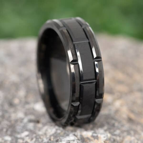 8mm and black wedding band with line carvings at intervals on the brushed center and polished edges.