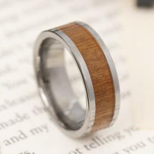 An 8mm men's wedding band featuring a Rowan wood inlay, straight edge design, and a polished finish extending to its sleeve.
