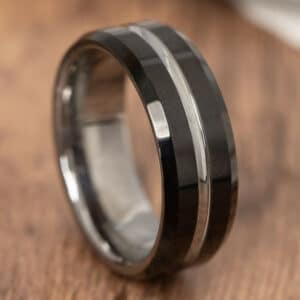 A black wedding band with features such as a silver pinstripe and sleeve, and black sides and edges with a polished finish.