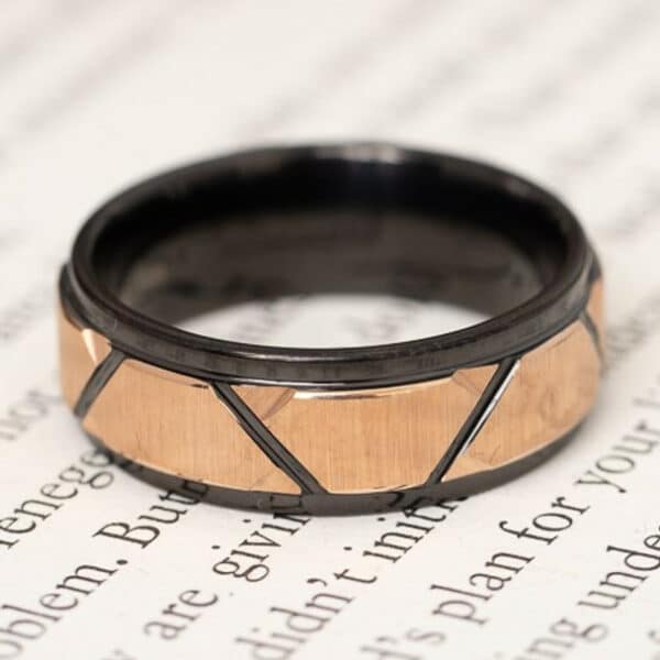 A 8mm black men's tungsten wedding ring featuring a faceted rose gold plated inlay, beveled edges and polished finish.